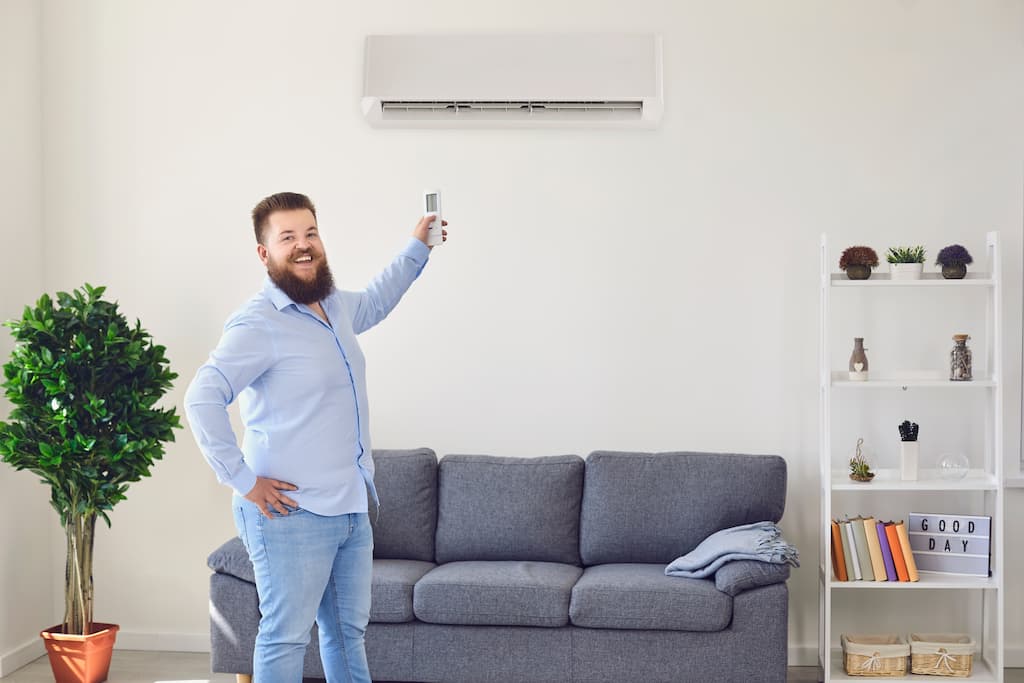Man with a MiniSplit HVAC unit and remote